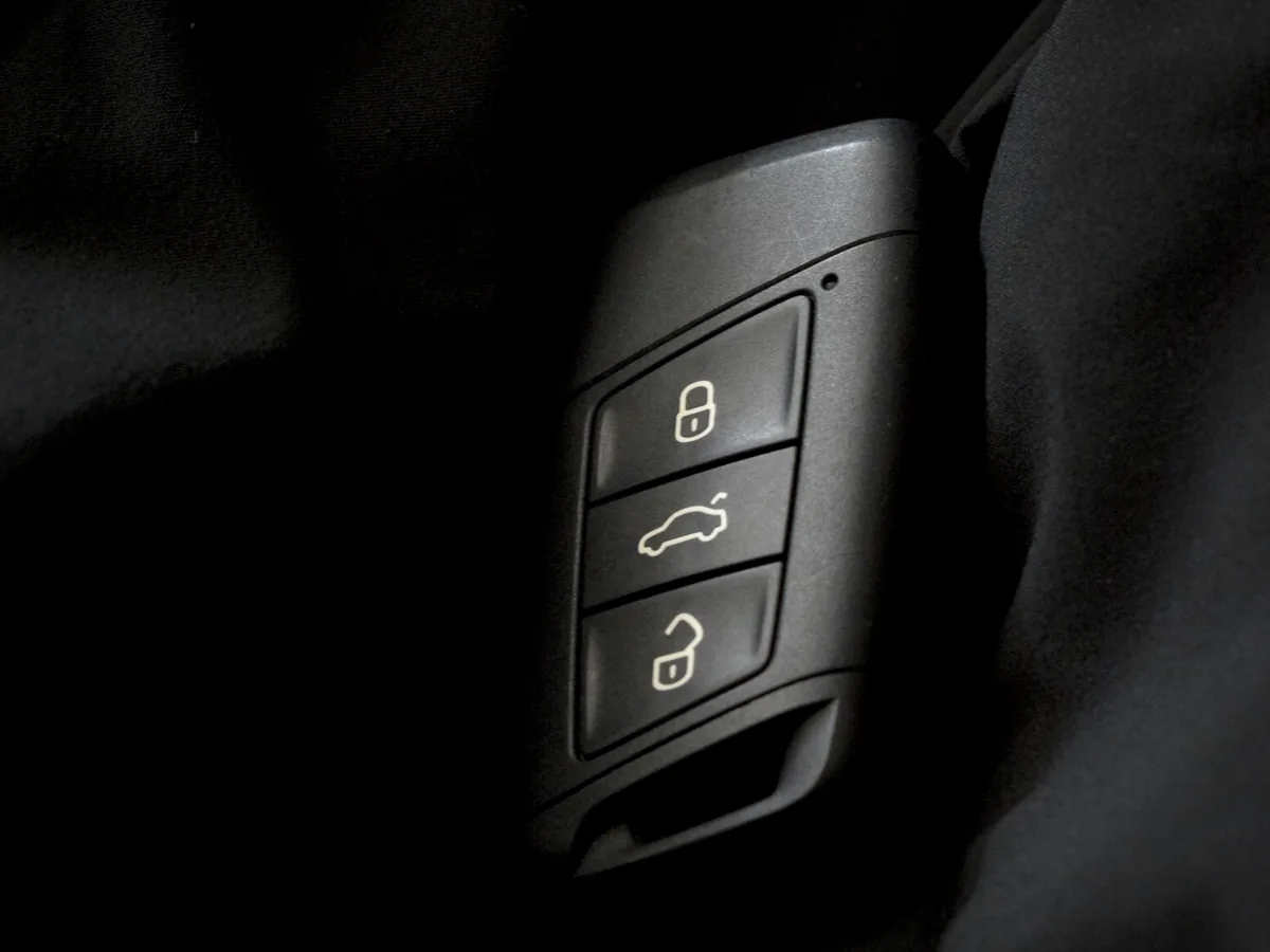 Black flip-style car remote key with lock, trunk and unlock buttons
